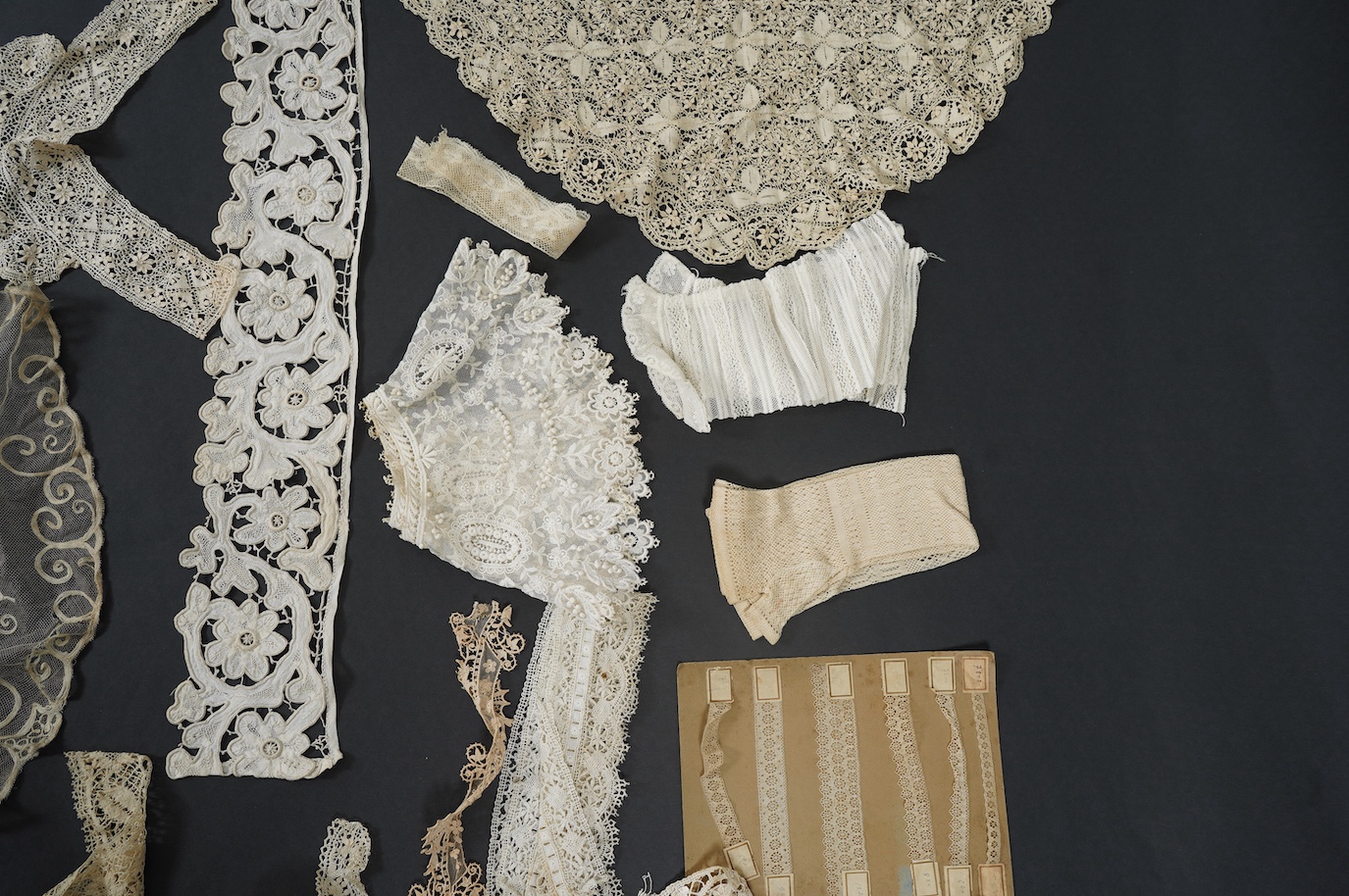 A needle run embroidered net skirt, a similar Bertha, five large silk Maltese bobbin lace collars and trimming, a length of Venetian style lace, mittens etc. Condition - good